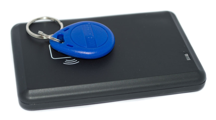 An RFID key fob is placed on an RFID reader